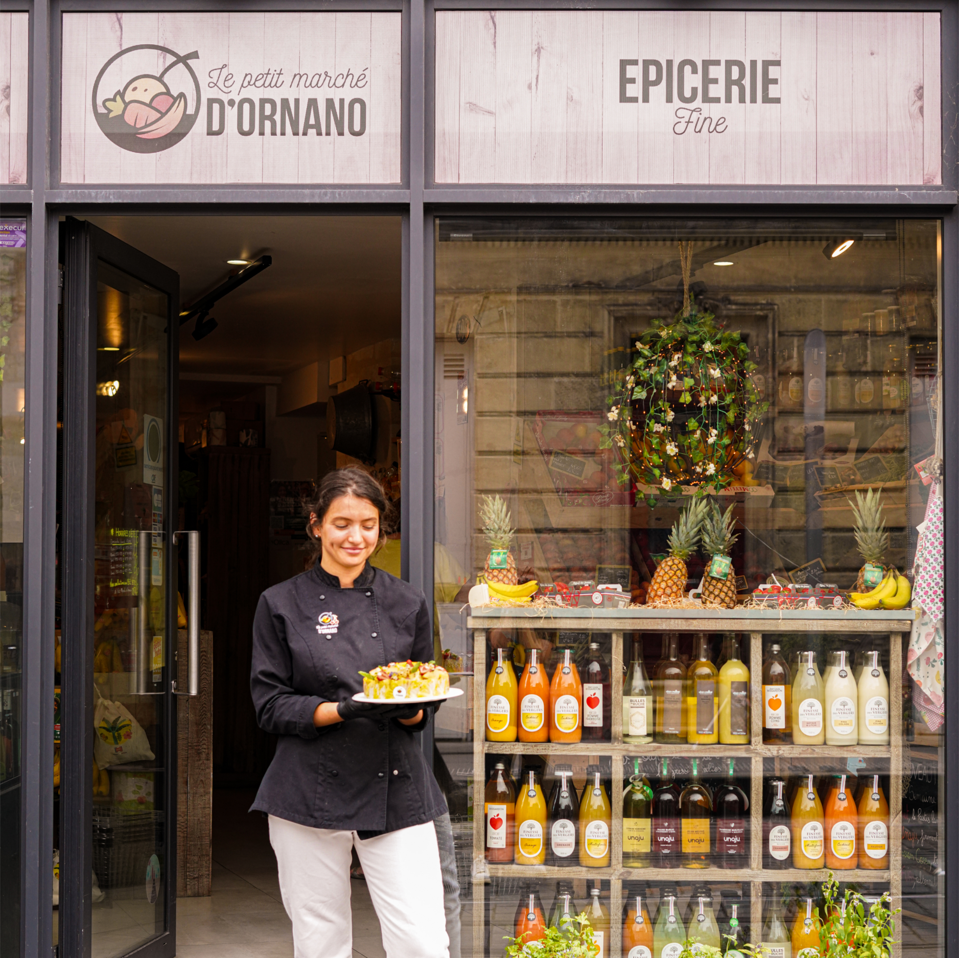 Axelle présentant une salade de fruits devant la boutique du Petit Marché d'Ornano